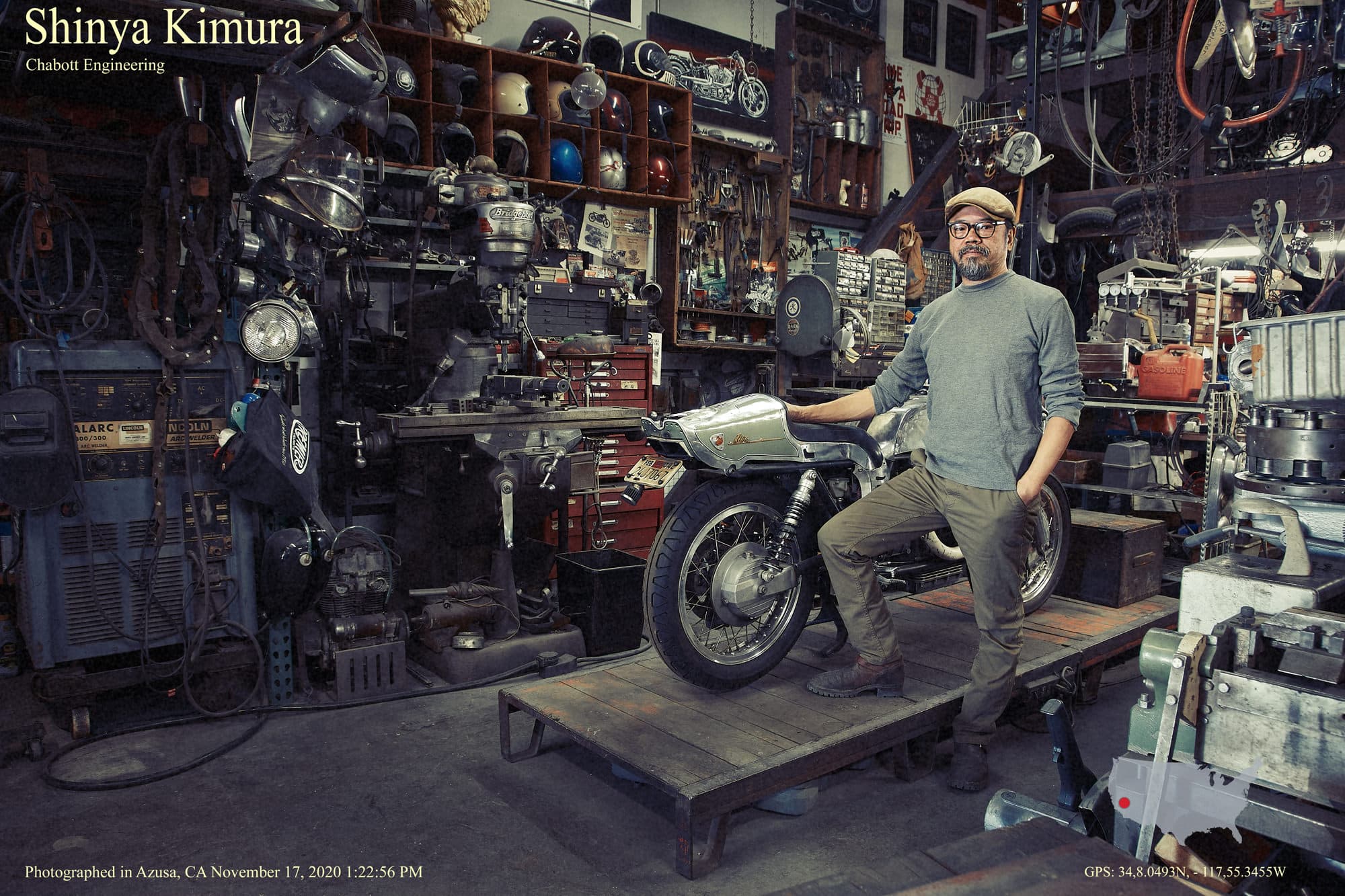 Raj beside a motorcycle in a workshop